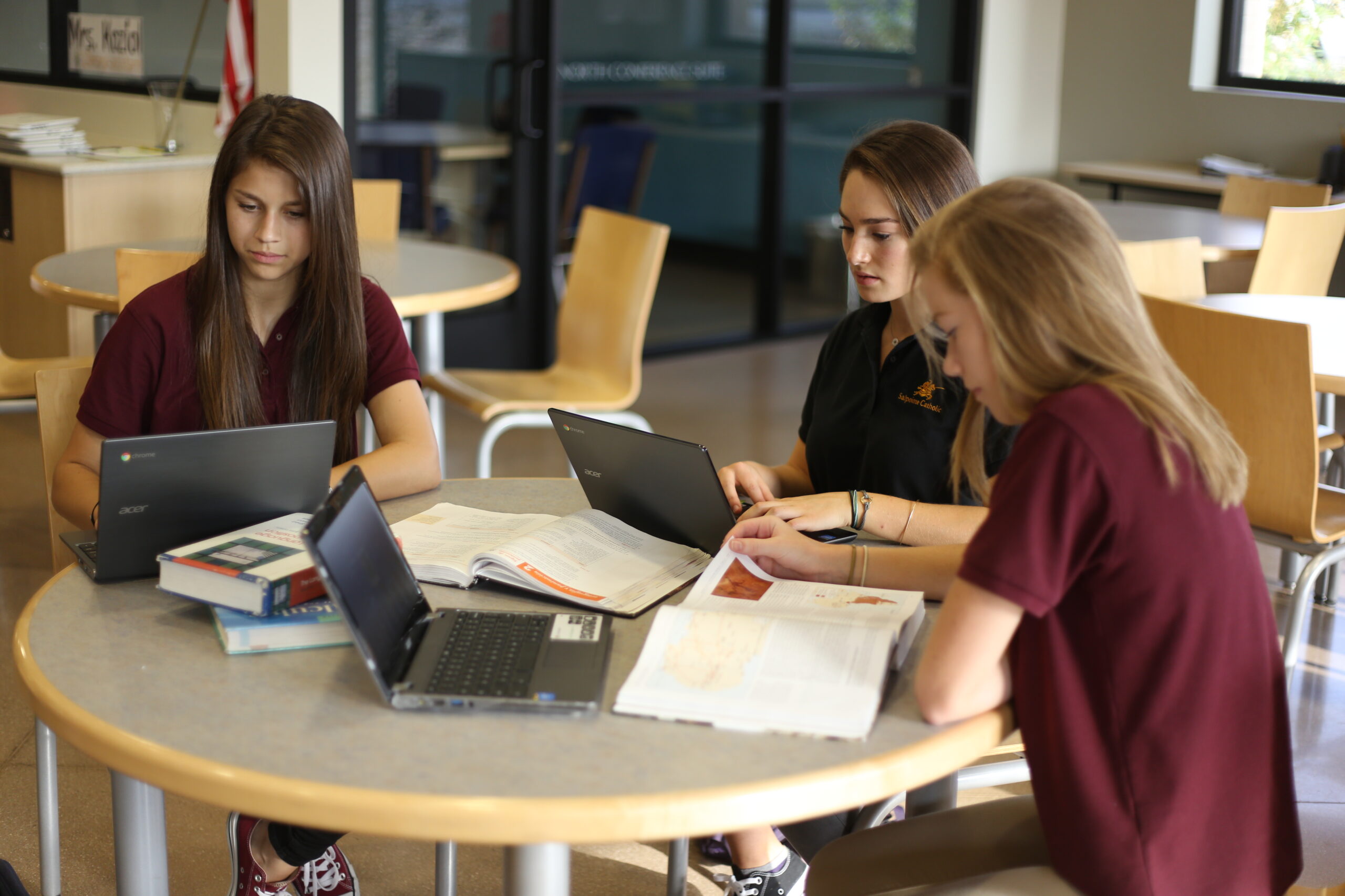 Students gathered around a table with laptops