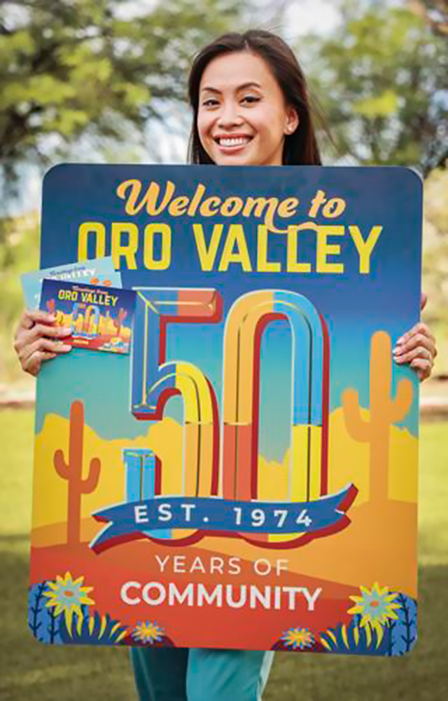 Alumna holding Town of Oro Valley sign